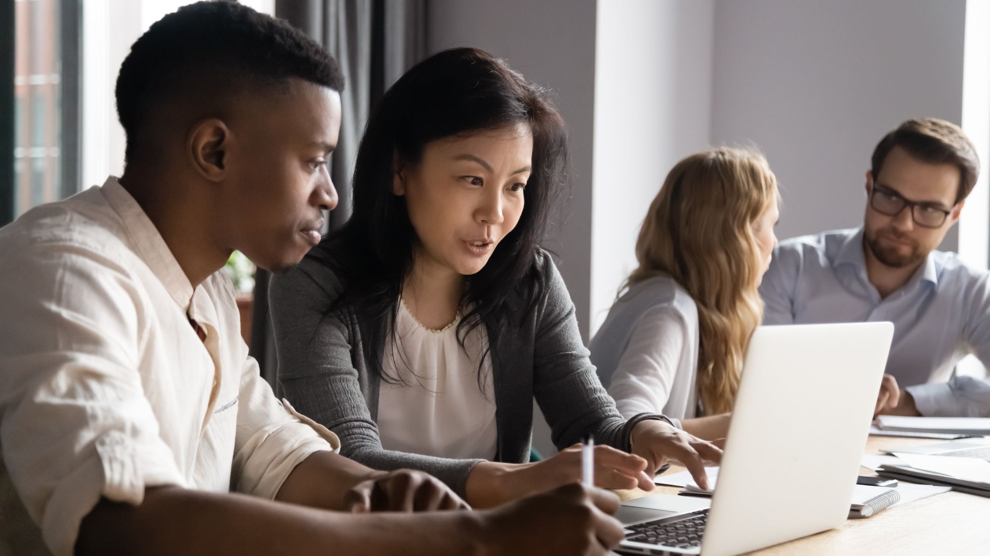 A group of people reviewing data on a laptop