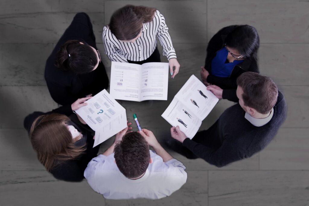 Top-down view of a team reviewing booklets